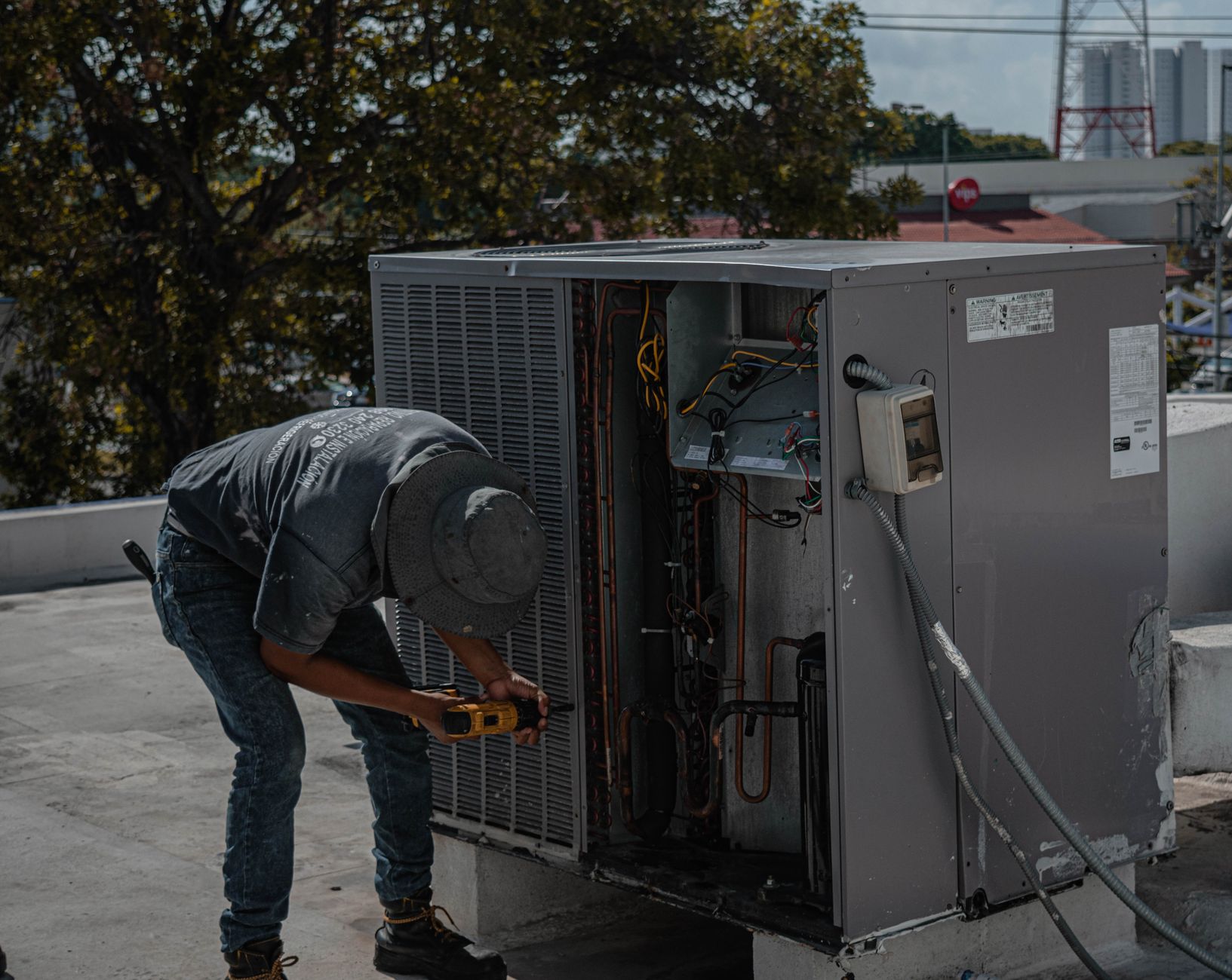 Technician repairing a rooftop air conditioning unit